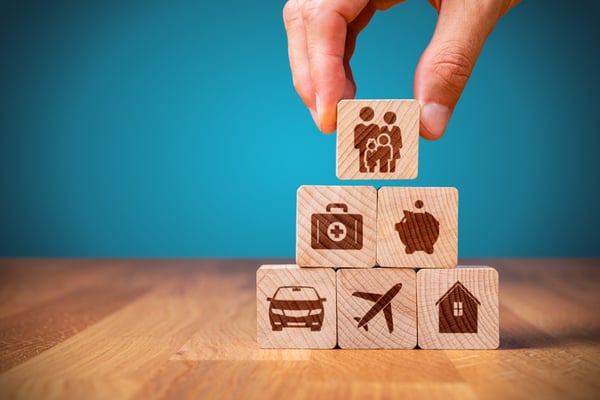 a pyramid of wooden blocks all signifying a different component of insurance